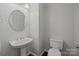 Clean powder room featuring a pedestal sink, modern fixtures, and a neutral color palette at 3206 Lakehurst Xing, Matthews, NC 28104