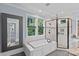 Bright bathroom features a tub with shower, large mirror, and tile flooring at 331 Solomon St, Charlotte, NC 28216