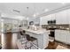 Bright kitchen features white cabinetry, stainless appliances, island with pendant lighting, and adjacent living space at 344 Linestowe Dr, Belmont, NC 28012
