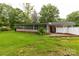 Back exterior view of home featuring a screened-in porch and a lush green yard at 405 N Woodland Dr, Lancaster, SC 29720