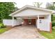 Home exterior featuring a covered carport and white picket fence at 405 N Woodland Dr, Lancaster, SC 29720