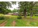 A charming brick home with mature trees and greenery along the front lawn at 405 N Woodland Dr, Lancaster, SC 29720