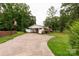Exterior home view showing the driveway, carport, landscaping and surrounding trees at 405 N Woodland Dr, Lancaster, SC 29720