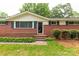 A close-up of the front of a charming brick home with a well-manicured landscape at 405 N Woodland Dr, Lancaster, SC 29720