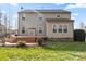 Back of house featuring a wooden deck with steps, a stone firepit area, and lush green grass at 4095 Harmattan Dr, Denver, NC 28037