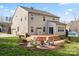 A spacious backyard features a wooden deck, a fire pit, and lush landscaping at 4095 Harmattan Dr, Denver, NC 28037