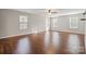 Expansive room featuring hardwood floors, neutral walls, sunny windows, and ceiling fan with plenty of open space at 4095 Harmattan Dr, Denver, NC 28037
