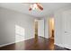 Bedroom featuring hardwood floors, a ceiling fan, and doorway access to an ensuite bathroom and walk in closet at 4095 Harmattan Dr, Denver, NC 28037