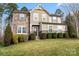 Charming two-story home with stone accents, well-manicured lawn, and lush landscaping at 4095 Harmattan Dr, Denver, NC 28037