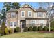 Charming two-story home with stone accents, well-manicured lawn, and lush landscaping at 4095 Harmattan Dr, Denver, NC 28037