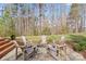 A stone fire pit has Adirondack chairs on a stone paver patio surrounded by a wooded backdrop at 4095 Harmattan Dr, Denver, NC 28037