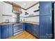 Kitchen featuring stainless steel appliances, blue cabinets with gold hardware, and a wood stove hood at 436 Third Baxter St, Fort Mill, SC 29708