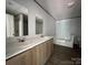 Bathroom featuring dual sinks, tub, neutral wall color, and wood-look floors at 493 Eagle Mills Rd, Hamptonville, NC 27020
