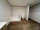 Bathroom features tub, toilet, and closet space with neutral wall color and wood-look floors at 493 Eagle Mills Rd, Hamptonville, NC 27020