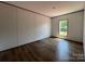 Spacious bedroom features wood-look flooring and ample natural light from a window at 493 Eagle Mills Rd, Hamptonville, NC 27020