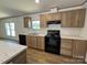 Modern kitchen featuring black appliances and wood-look cabinets at 493 Eagle Mills Rd, Hamptonville, NC 27020