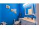 Bright blue half-bathroom with updated vanity, fixtures, mirror, and toilet at 5003 Singletree Ln, Indian Trail, NC 28079