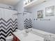 Bathroom featuring a double vanity sink, toilet, and shower with unique chevron shower curtain at 5003 Singletree Ln, Indian Trail, NC 28079