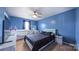 A blue bedroom with a modern ceiling fan, a TV, a baby bed, and a window at 5003 Singletree Ln, Indian Trail, NC 28079