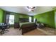 This bedroom features green walls, a ceiling fan, carpet, and a wooden bed frame at 5003 Singletree Ln, Indian Trail, NC 28079