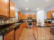 Bright kitchen with warm wood cabinets, stainless steel appliances, and black granite countertops at 5003 Singletree Ln, Indian Trail, NC 28079