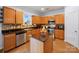 Well-lit kitchen featuring warm wood cabinets, stainless steel appliances, and a center island at 5003 Singletree Ln, Indian Trail, NC 28079