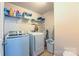 The laundry room includes a washer, dryer, and overhead shelving for storage at 5003 Singletree Ln, Indian Trail, NC 28079