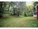 Expansive backyard featuring lush green grass and mature trees offering serene privacy at 506 Richards Dr, Shelby, NC 28150