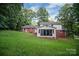 House exterior with a large, well-kept lawn, brick accents, and a screened in porch at 506 Richards Dr, Shelby, NC 28150