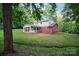 Large, well-maintained yard behind a home with brick and siding, complemented by a screened-in porch at 506 Richards Dr, Shelby, NC 28150