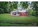 View of the house exterior from a sprawling backyard with mature trees and a screened porch at 506 Richards Dr, Shelby, NC 28150