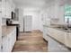 Well-lit kitchen boasting white cabinets, stainless steel appliances, and updated countertops, creating a modern cooking space at 506 Richards Dr, Shelby, NC 28150