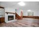 Cozy living room featuring a brick fireplace, wood paneling, and updated flooring at 506 Richards Dr, Shelby, NC 28150