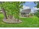 Lush backyard features mature trees, rock gardens, and a screened-in porch for relaxing outdoor living at 562 Preservation Dr, Fort Mill, SC 29715