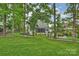 Beautiful backyard with a well-manicured lawn, mature trees, and lovely landscaping surrounding the back of the home at 562 Preservation Dr, Fort Mill, SC 29715