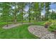 Expansive backyard with rock beds around mature trees offers a serene and inviting outdoor space at 562 Preservation Dr, Fort Mill, SC 29715