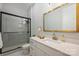 This bathroom has a glass enclosed shower and white granite vanity with a gold faucet and accent mirror at 562 Preservation Dr, Fort Mill, SC 29715
