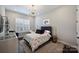 This bedroom features natural light and a decorative light fixture with a neutral patterned duvet and matching curtains at 562 Preservation Dr, Fort Mill, SC 29715