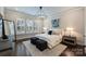 Bright bedroom with comfortable bed, ottomans, natural light, and dark wood flooring at 562 Preservation Dr, Fort Mill, SC 29715