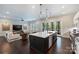 Open concept kitchen with large island open to living room and sliders to outdoor dining area. Hardwood floors throughout at 562 Preservation Dr, Fort Mill, SC 29715