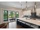 Stylish kitchen boasts a large island with seating, pendant lights, and direct access to the outdoor dining area and pool at 562 Preservation Dr, Fort Mill, SC 29715