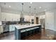 Spacious kitchen features a large island with seating, pendant lights, stainless steel appliances, and sleek white cabinetry at 562 Preservation Dr, Fort Mill, SC 29715
