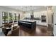 Modern kitchen features a large island with seating, pendant lighting, stainless steel appliances and white cabinets at 562 Preservation Dr, Fort Mill, SC 29715