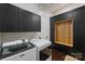 Laundry room with Maytag washer and dryer, dark cabinets, and a wood slat feature for storage at 562 Preservation Dr, Fort Mill, SC 29715