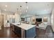 Open concept living room and kitchen with stainless steel appliances and dark wood flooring at 562 Preservation Dr, Fort Mill, SC 29715