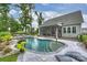 Backyard view of a freeform pool with patio area and screened-in porch on home at 562 Preservation Dr, Fort Mill, SC 29715