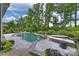 Backyard freeform pool with lounge chairs, landscaping, and manicured lawn at 562 Preservation Dr, Fort Mill, SC 29715