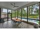 Screened-in porch with dining area and a view of the pool and wooded backyard at 562 Preservation Dr, Fort Mill, SC 29715
