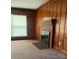 This home features a living room with wood paneling, a brick fireplace, and a window with blinds at 610 E Maryland Ave, Bessemer City, NC 28016