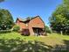 Rear exterior view of a red brick home, garage and well-maintained yard at 675 Godbey Rd, Salisbury, NC 28147